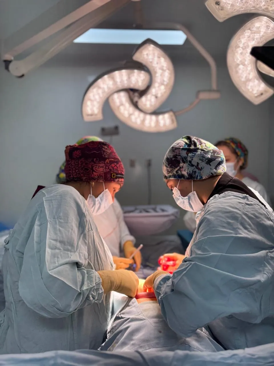 Dos integrantes del equipo médico trabajando durante un procedimiento quirúrgico
